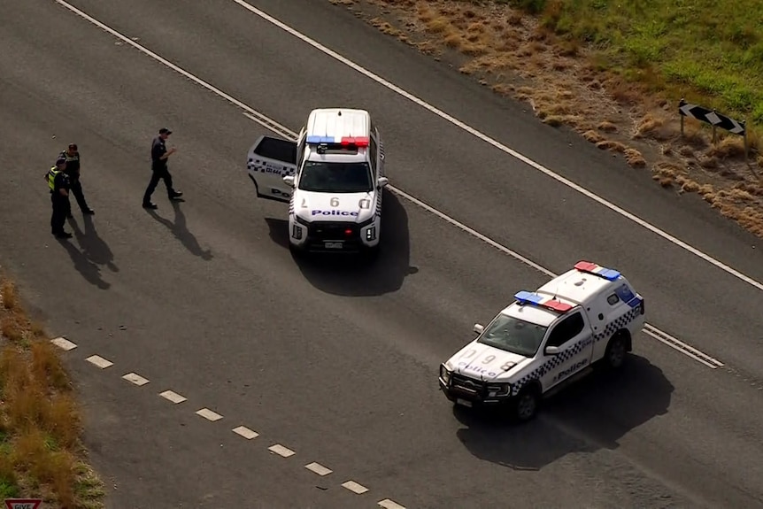Police cars and officers on a highway,