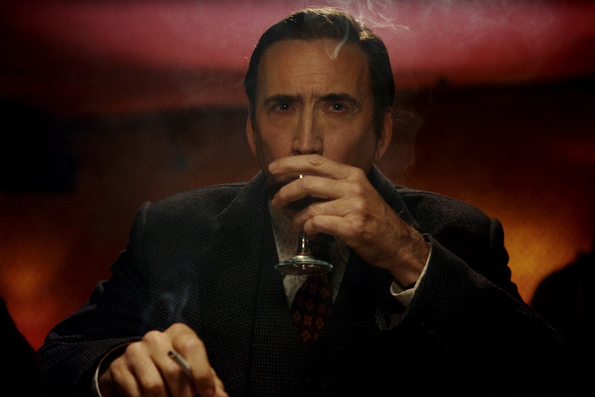 A man sits in a bar drinking a cocktail.