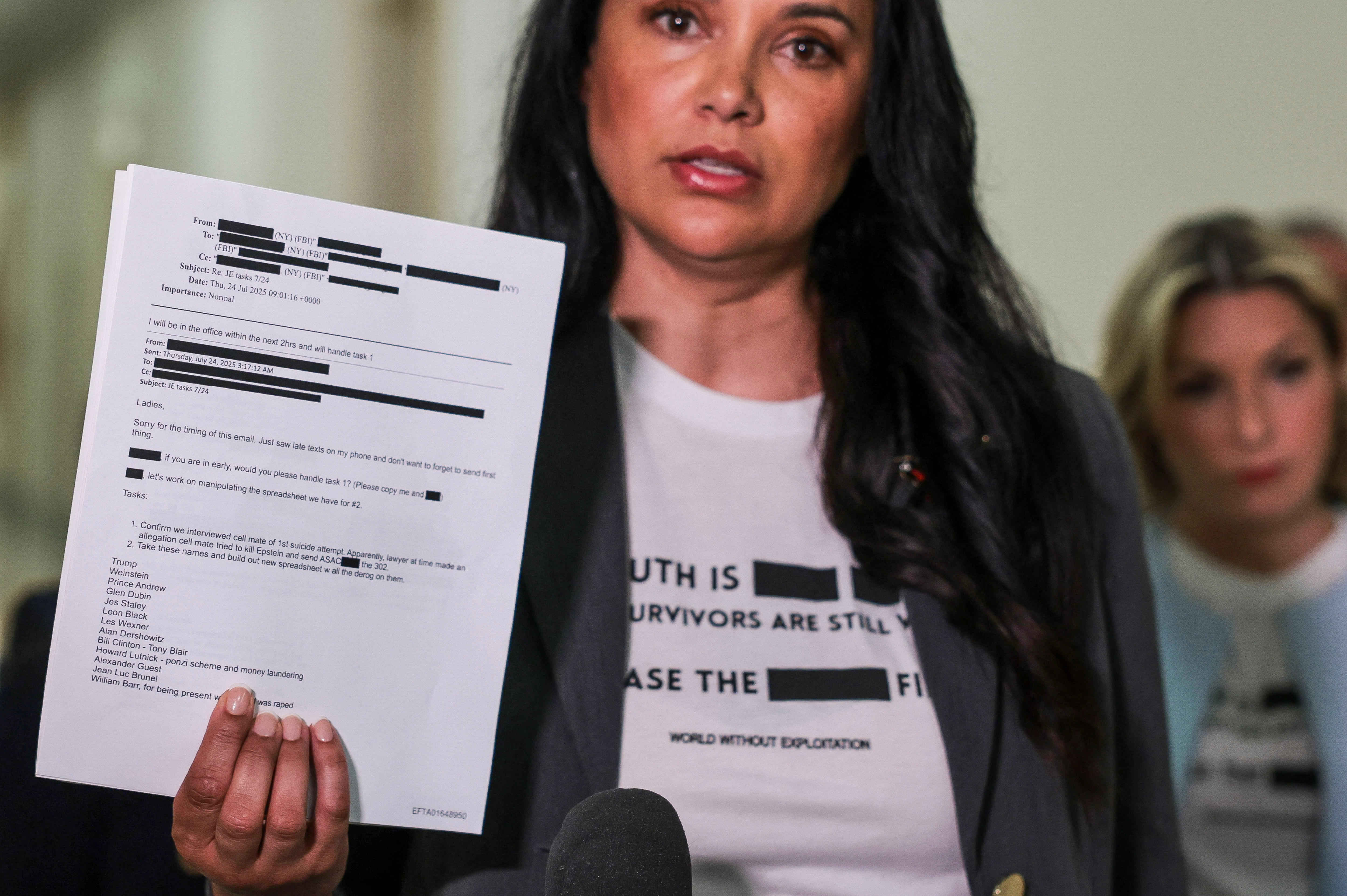 an Epstein survivor holds a document showing some of the released files