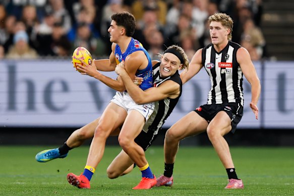 Moore lays a tackle on Josh Lindsay before he was forced out of Scott Pendlebury’s 433rd game with a hamstring issue.