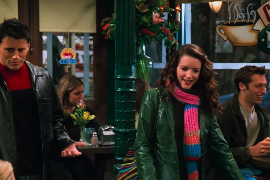 A coffee shop scene from Friends with Joey and his girlfriend in the foreground and Ian Thorpe in the background.