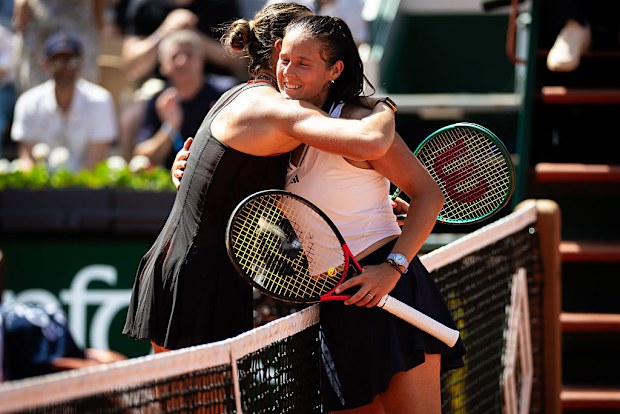 Daria Kasatkina and Aryna Sabalenka embrace at the net.