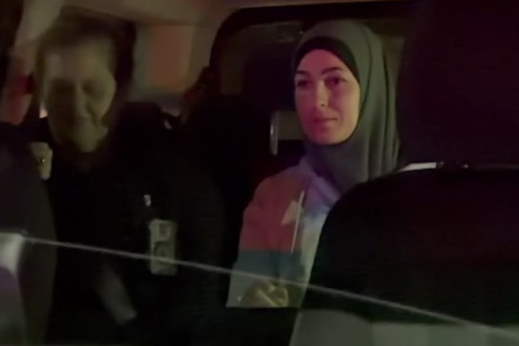 An arrested woman in the back of a car