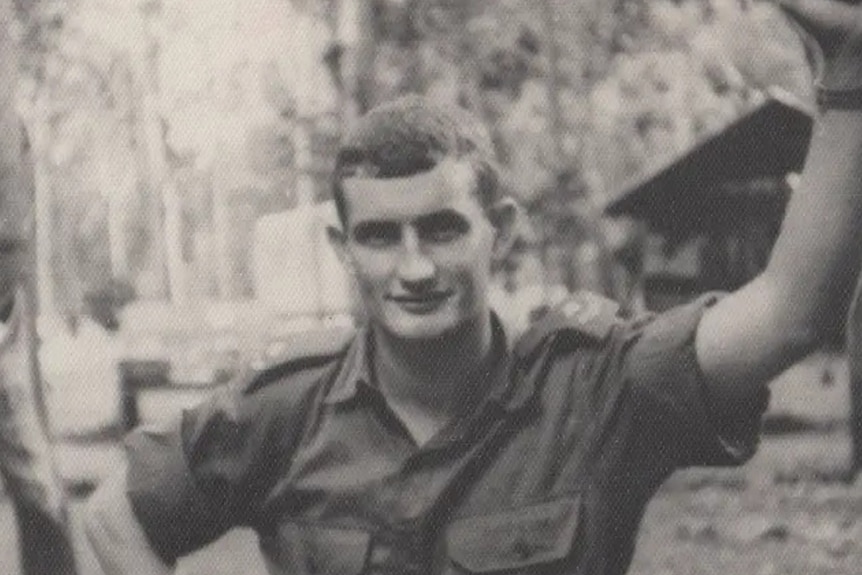 A black and white photo of John O'Halloran in army clothes smiling for the photo.