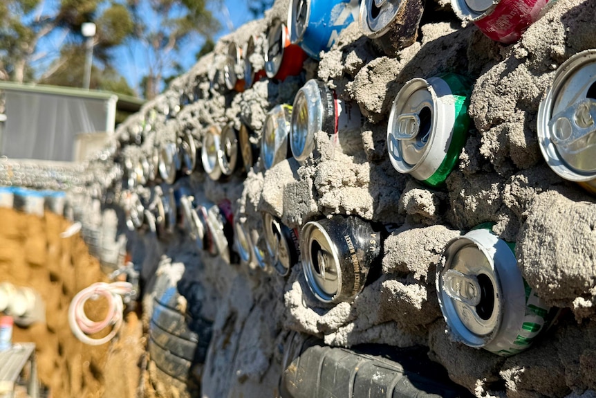 cans in a mud wall