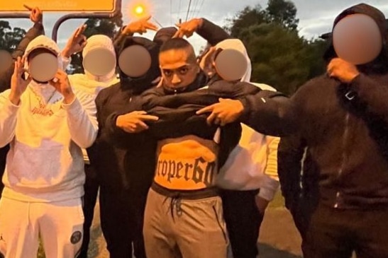 Lorenzo Lemalu with a group of men lifting his shirt up.