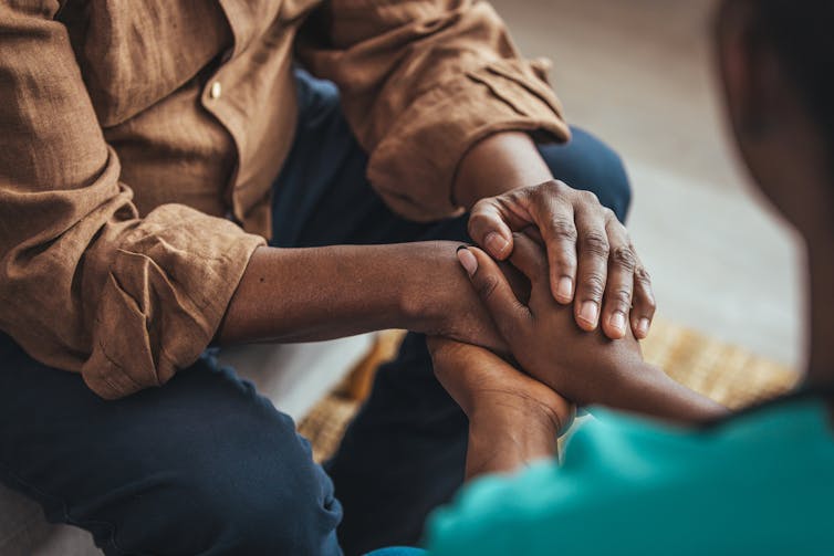 Close-up of two people clasping hands