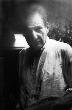 A black and white image of an old man staring at the camera.