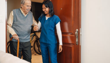 Old man assisted by a nurse during a home visit