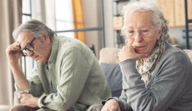 Mature couple sitting back to back not talking