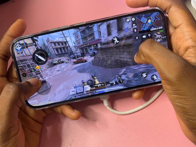 Hands holding phone and playing Call of Duty Mobile