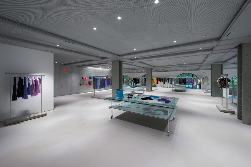 A store's mezzanine level with garments displayed on aluminium racks and tables