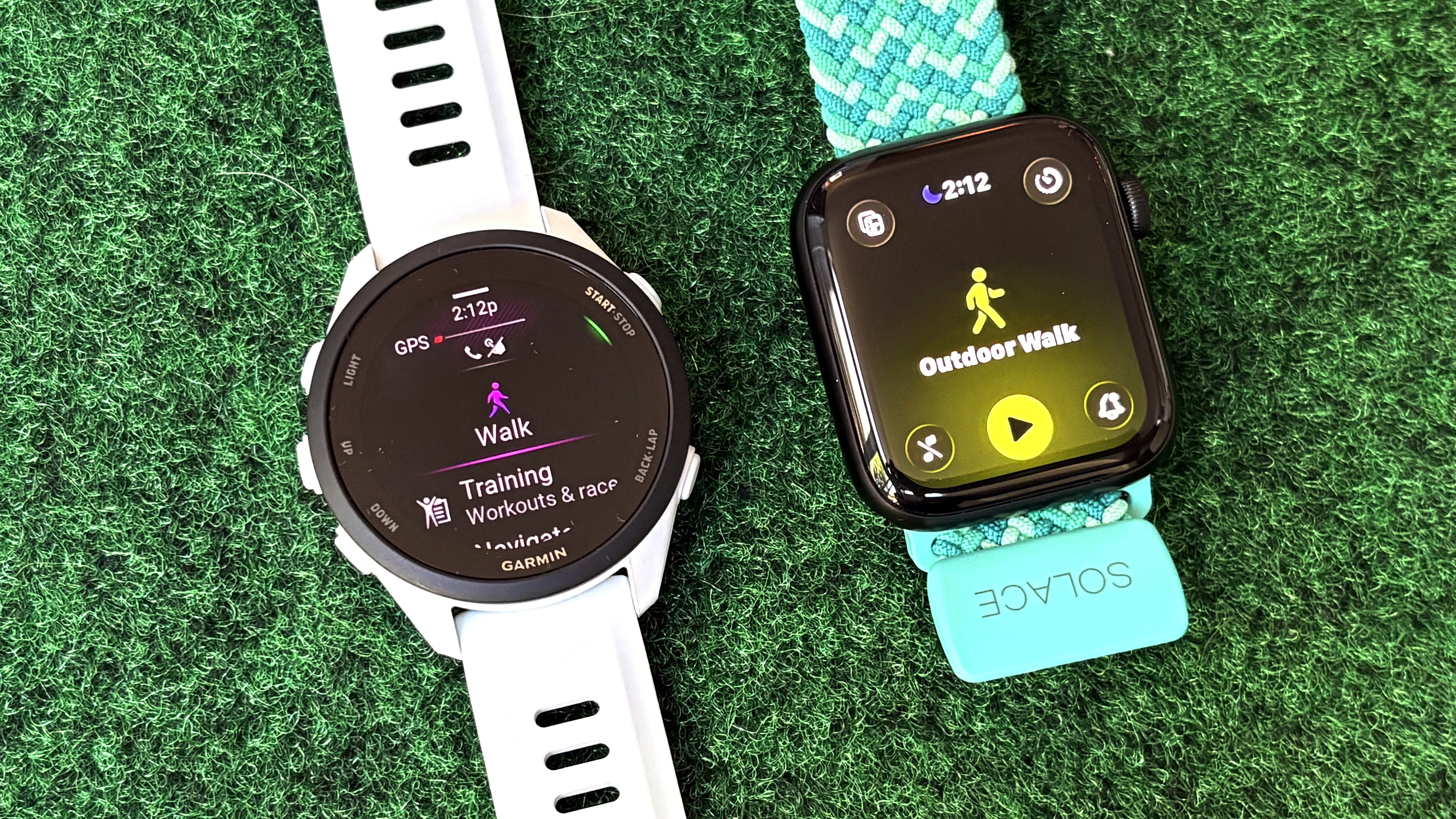 Close-up of the Apple Watch SE 3 next to the Garmin Forerunner 70