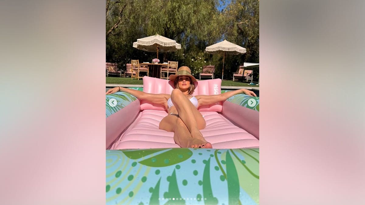 Jennifer Lopez lounging on a pink pool floatie on Memorial Day 2026.