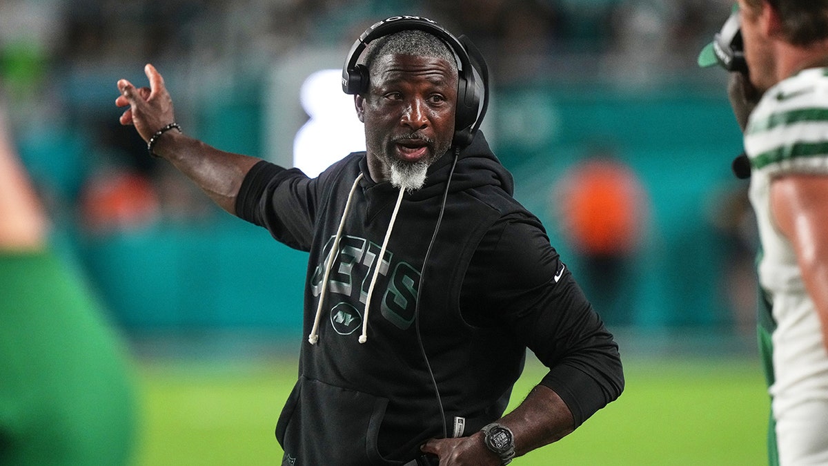 New York Jets head coach Aaron Glenn instructing staff on the sideline during a game