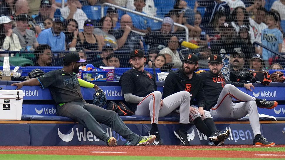 Tampa Bay Rays third baseman Junior Caminero, left, sits on the San Francisco Giants bullpen bench after chasing a foul ball by Luis Arraez during the sixth inning of a baseball game Saturday, May 2, 2026, in St. Petersburg, Fla. (AP Photo/Chris O'Meara)