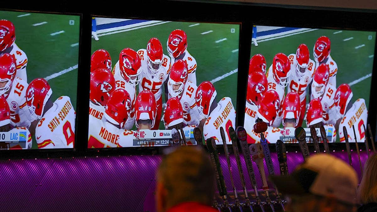 Bar patrons watching YouTube TV telecast of Kansas City Chiefs versus Los Angeles Chargers game