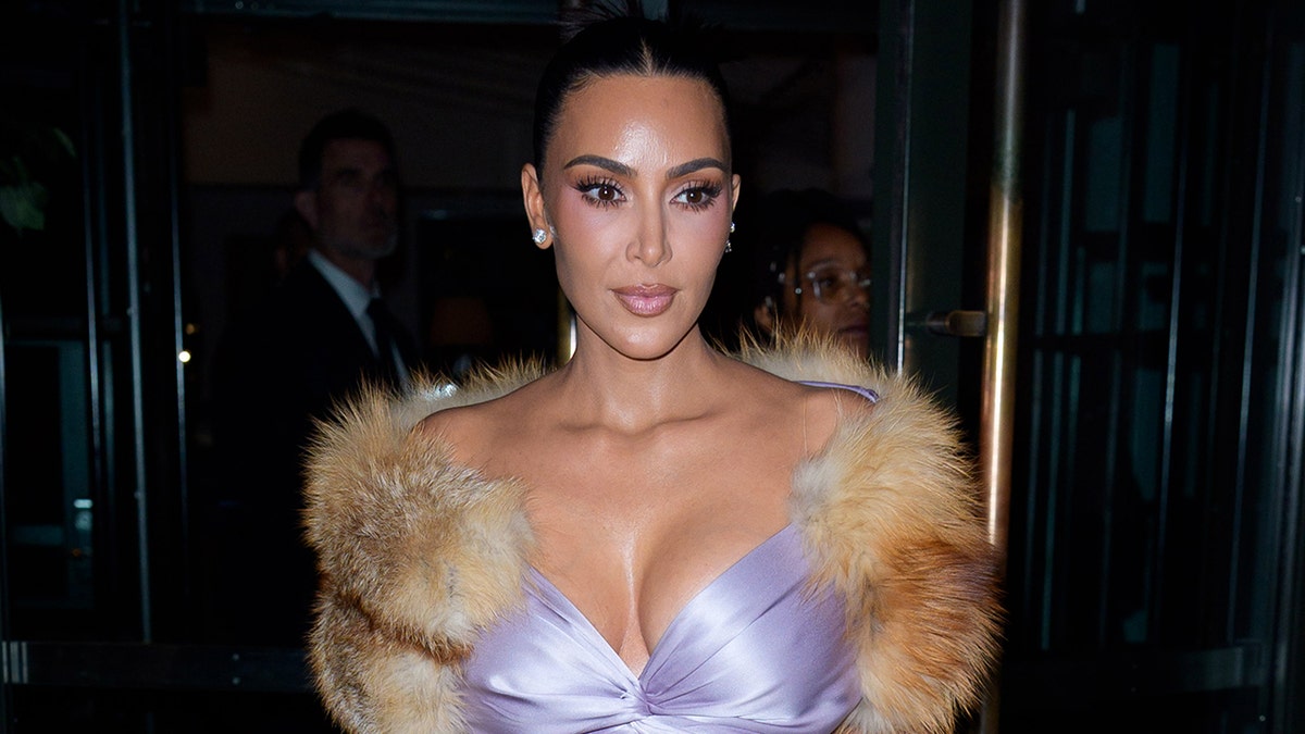 Kim Kardashian wearing a purple top walking in New York City