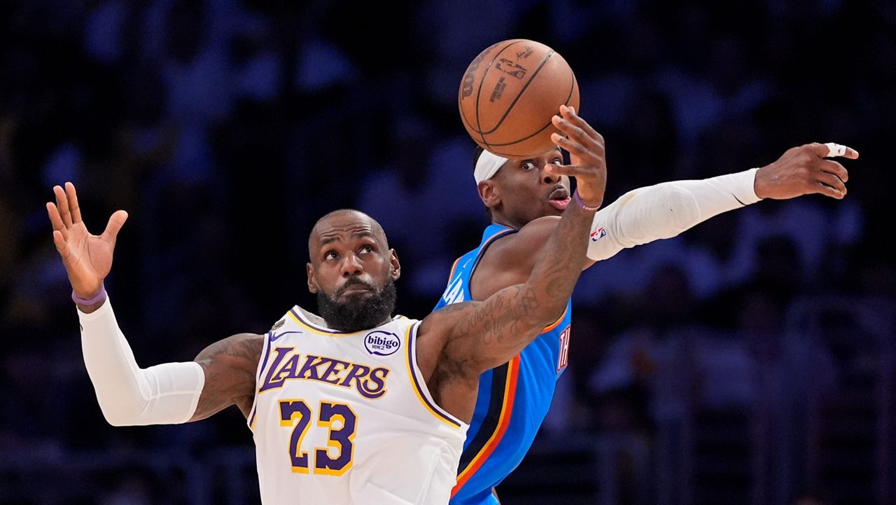Los Angeles Lakers forward LeBron James, left, takes a pass as Oklahoma City Thunder guard Shai Gilgeous-Alexander defends during the first half of Game 3 in a second-round NBA basketball playoffs series Saturday, May 9, 2026, in Los Angeles. (AP Photo/Mark J. Terrill)