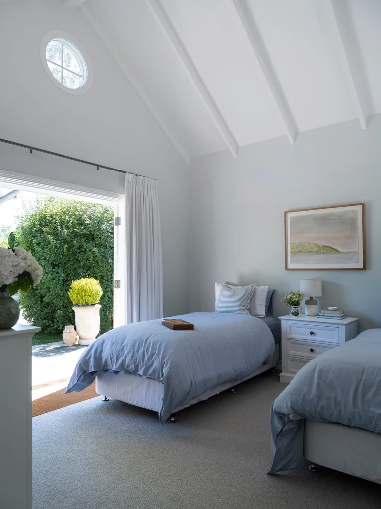 A children's bedroom with twin beds and blue bedding
