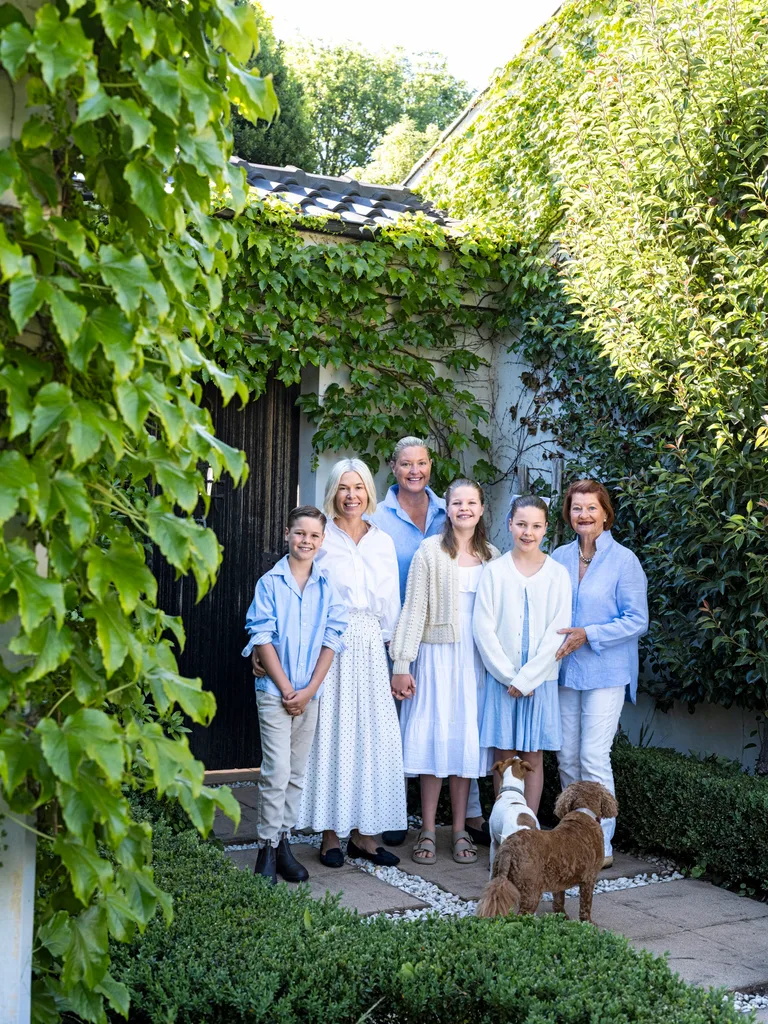 A family outside their ivy-covered home in the Southern Highlands