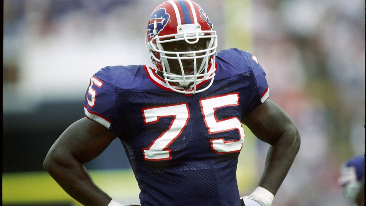 Marcellus Wiley standing and smiling in a studio setting