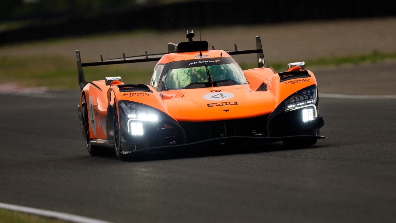 The McLaren MCL-HY hypercar on track in an orange test livery