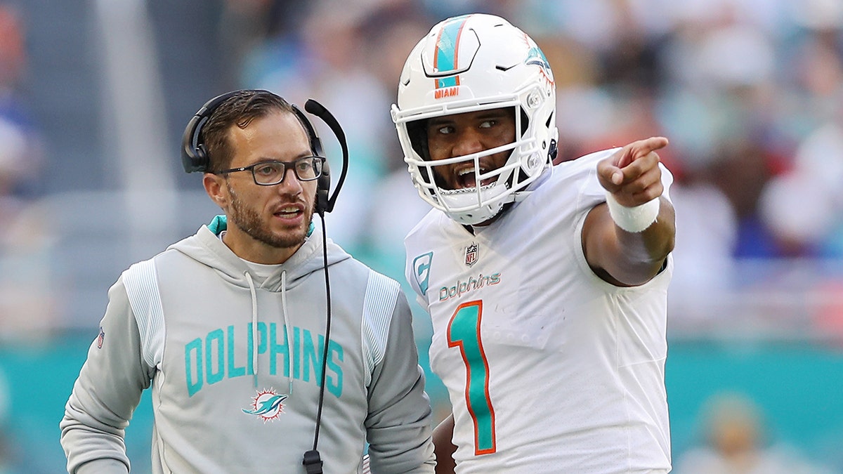 Mike McDaniel speaking with Miami Dolphins quarterback Tua Tagovailoa on the sidelines