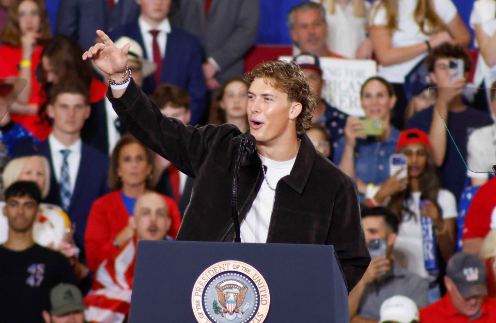 New York Giants quarterback Jaxson Dart speaking at a rally with a crowd in the background.