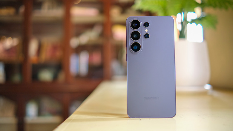 A silver Samsung Galaxy device stands tall on a table, the backside of the device is facing the camera