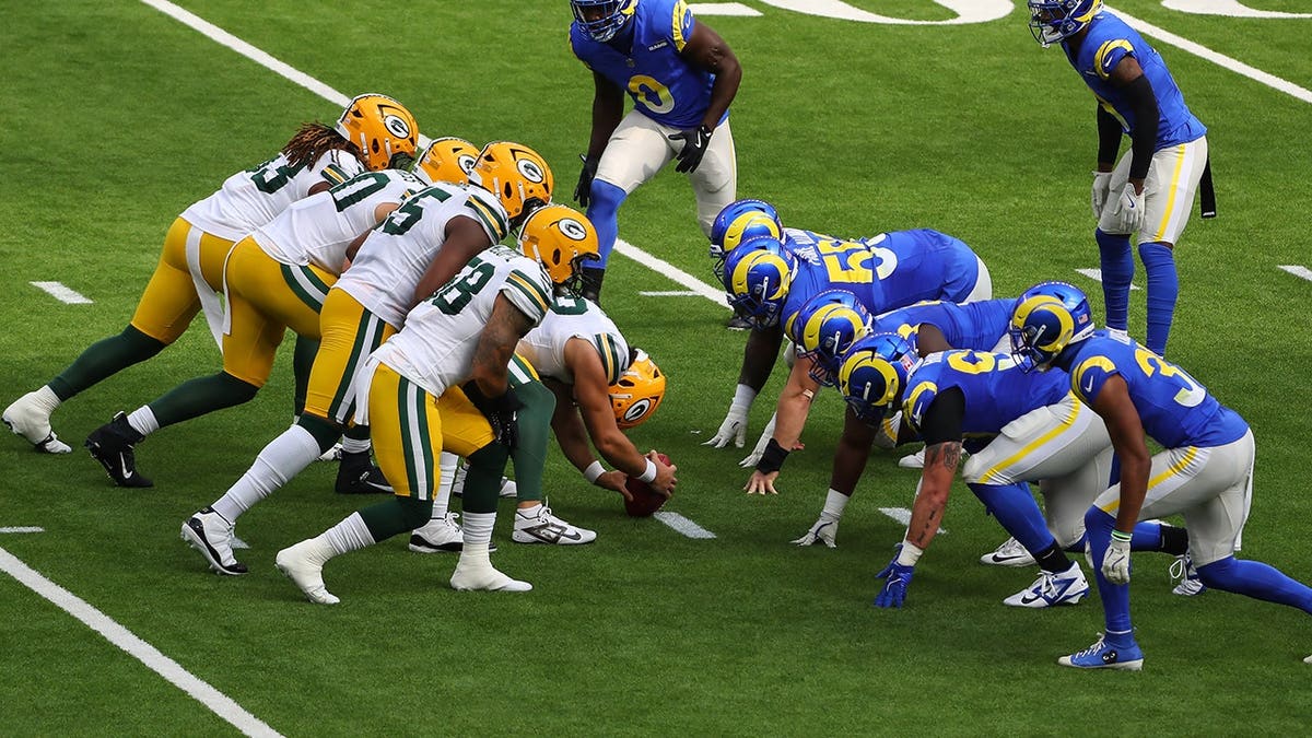 Green Bay Packers and Los Angeles Rams teams lined up at line of scrimmage during NFL game