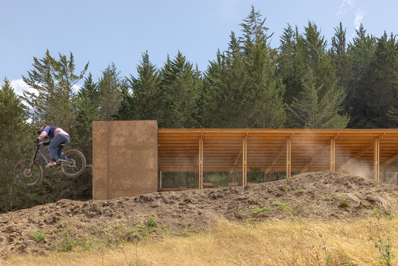 earth-toned concrete bike refuge emerges from ecuador’s reforested landscape - 2