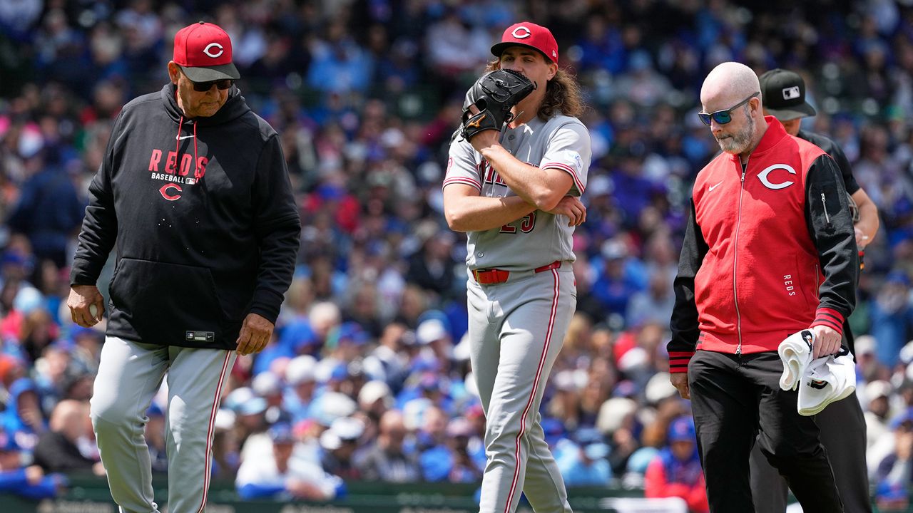 Cincinnati Reds starting pitcher Rhett Lowder, center, leaves with manager Terry Francona, left, and a team trainer after an injury during the fourth inning of a baseball game against the Chicago Cubs in Chicago, Thursday, May 7, 2026. (AP Photo/Nam Y. Huh)