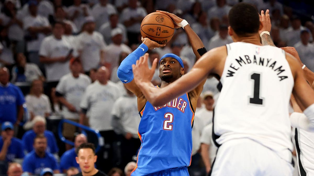 Oklahoma City Thunder guard Shai Gilgeous-Alexander shooting as San Antonio Spurs forward Victor Wembanyama defends