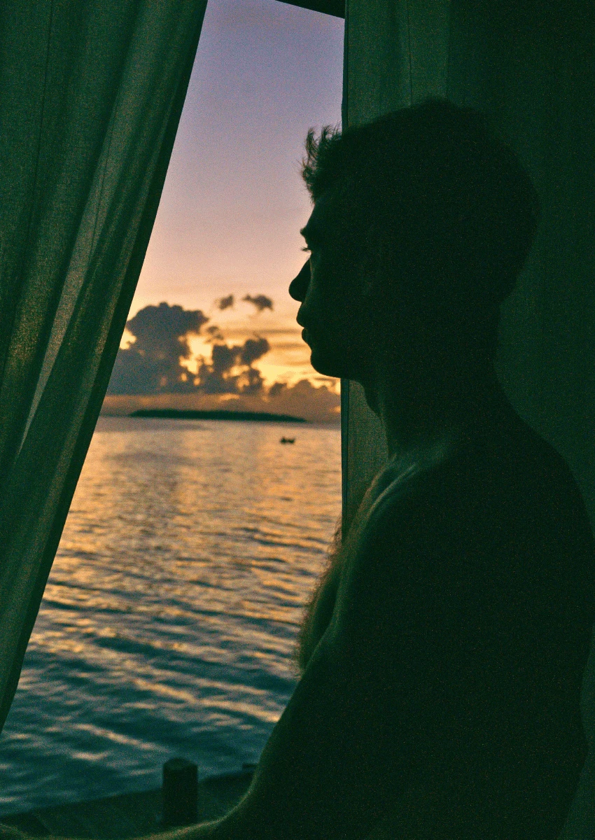 silhouette of thoughtful man looking out of window