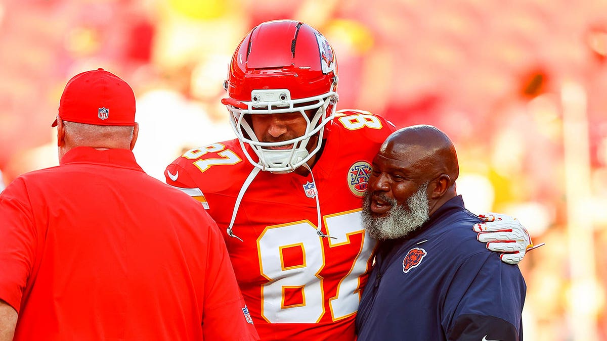 Travis Kelce greeting Eric Bieniemy with Andy Reid nearby at Arrowhead Stadium