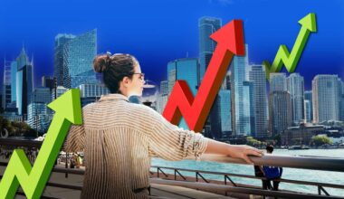 A woman looks across the water at high rise buildings, she is surrounded by large arrows pointing up