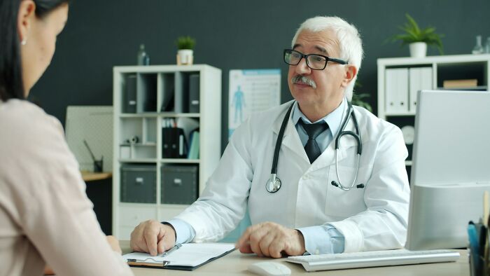 Medical worker in white coat consulting with a patient