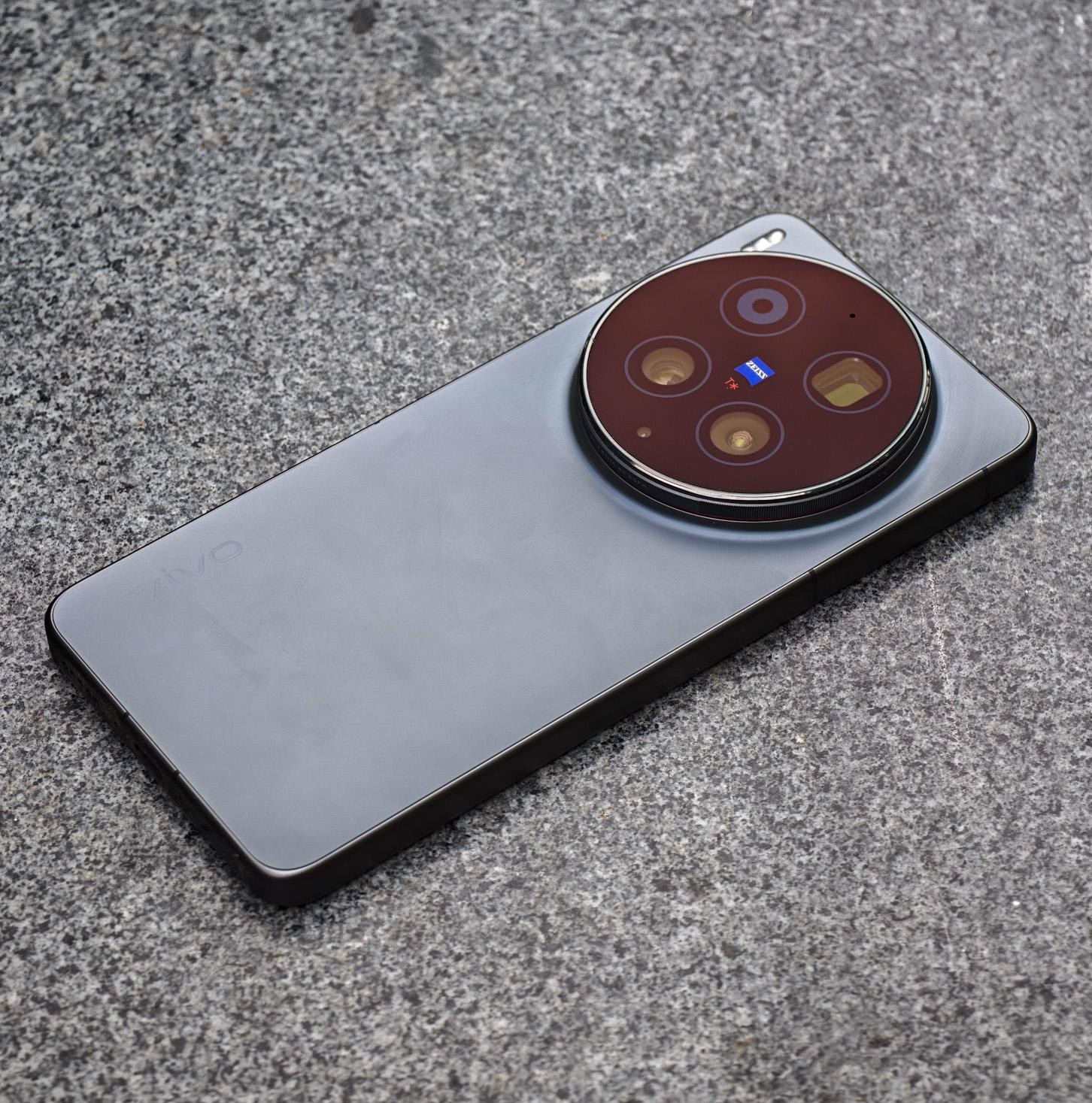 Photo of the Vivo X300 Ultra laying on a gray stone bench.