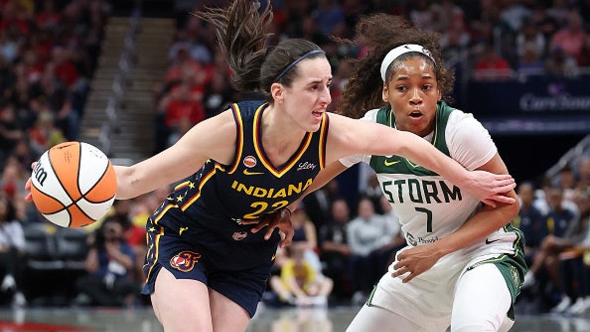 Caitlin Clark dribbling basketball defended by Zia Cooke at Gainbridge Fieldhouse