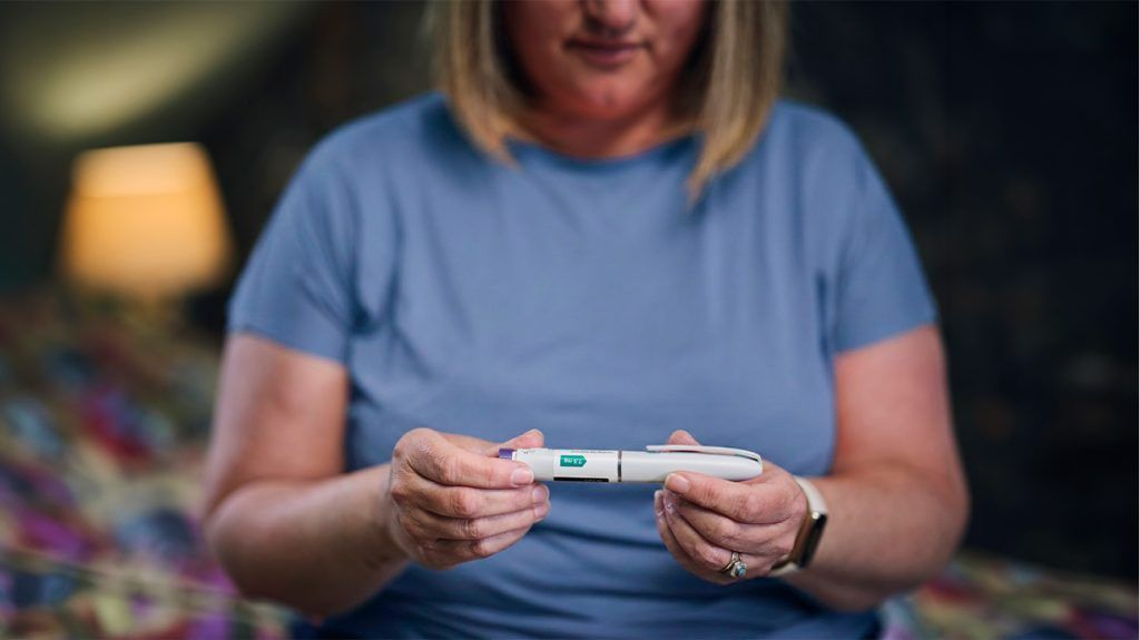 older white woman holding glp-1 injection dose