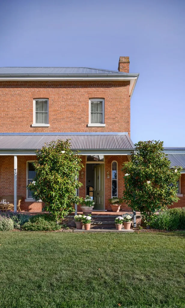 The red brick exterior of Yarras Homestead with a green front door left ajar
