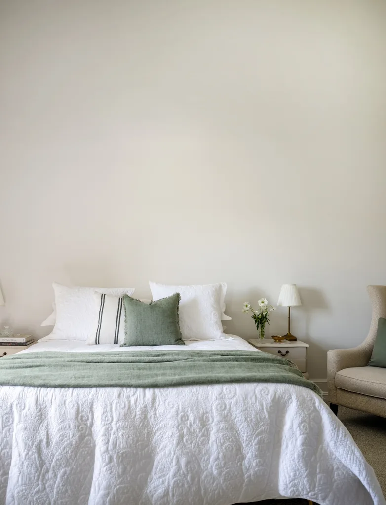 A white bedroom in a restored homestead