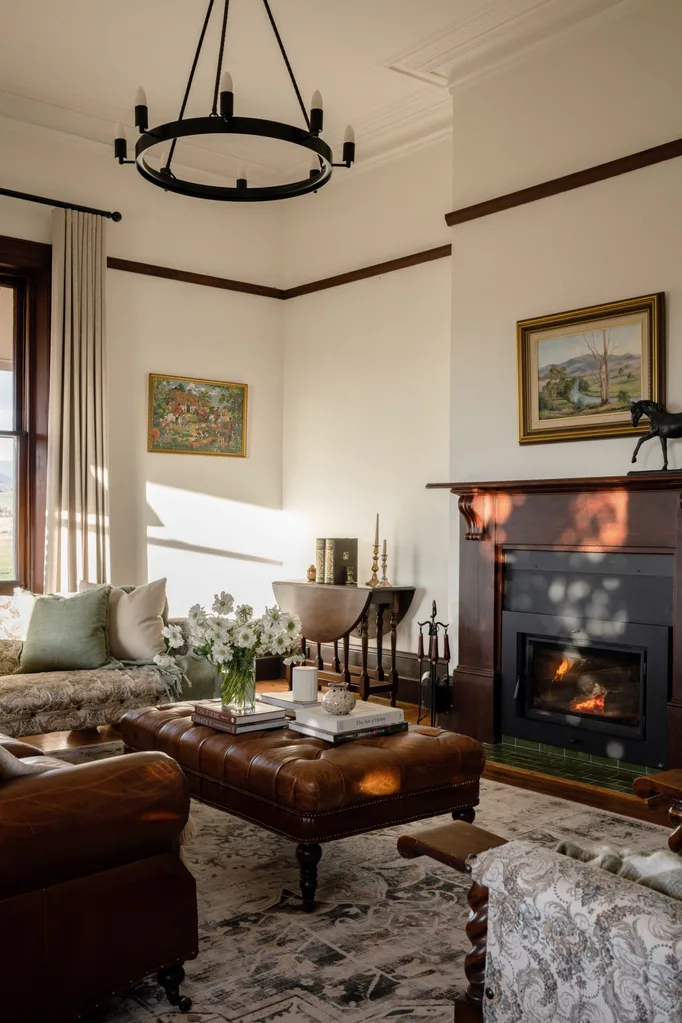 A lounge room with a timber fireplace and a modern chandelier