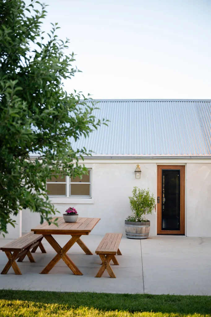 A white cottage with a concrete outdoor area on a property in Bathurst