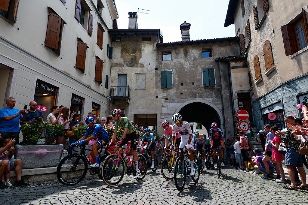 The pack of riders (peloton) cycle through the streets of Feltre at the start of the 19th stage of the Giro d'Italia 2026 - Tour of Italy cycling race between Feltre and Alleghe, Italy, on May 29, 2026. (Photo by Luca Bettini / AFP)