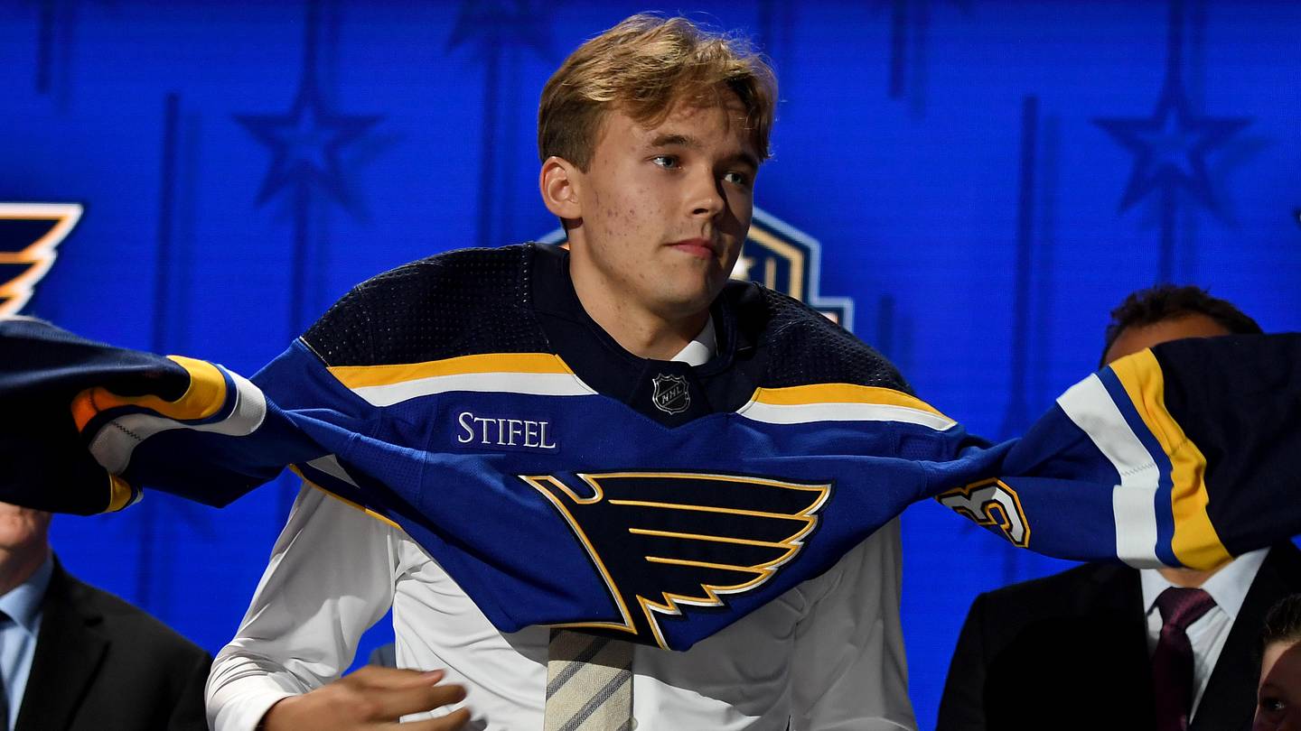 Jun 28, 2023; Nashville, Tennessee, USA; St. Louis Blues draft pick Theo Lindstein puts on his sweater after being selected with the twenty ninth pick in round one of the 2023 NHL Draft at Bridgestone Arena. Mandatory Credit: Christopher Hanewinckel-Imagn Images