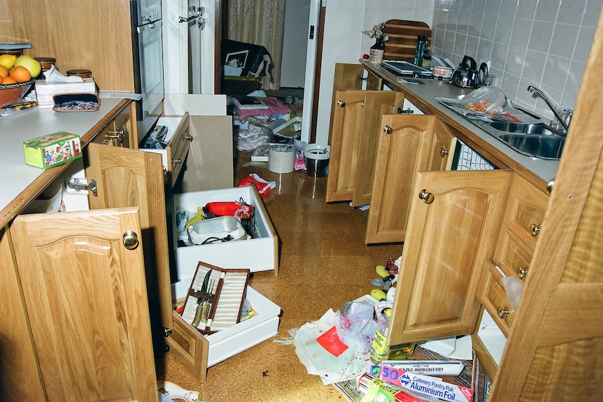Wooden kitchen cupboards left open and drawers on the floor.