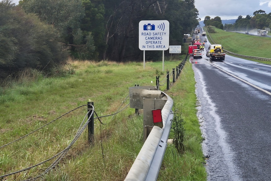 A damaged fence with a fuel tanker in the background.