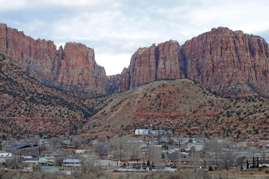 A town sits on the foothills of red cliffs